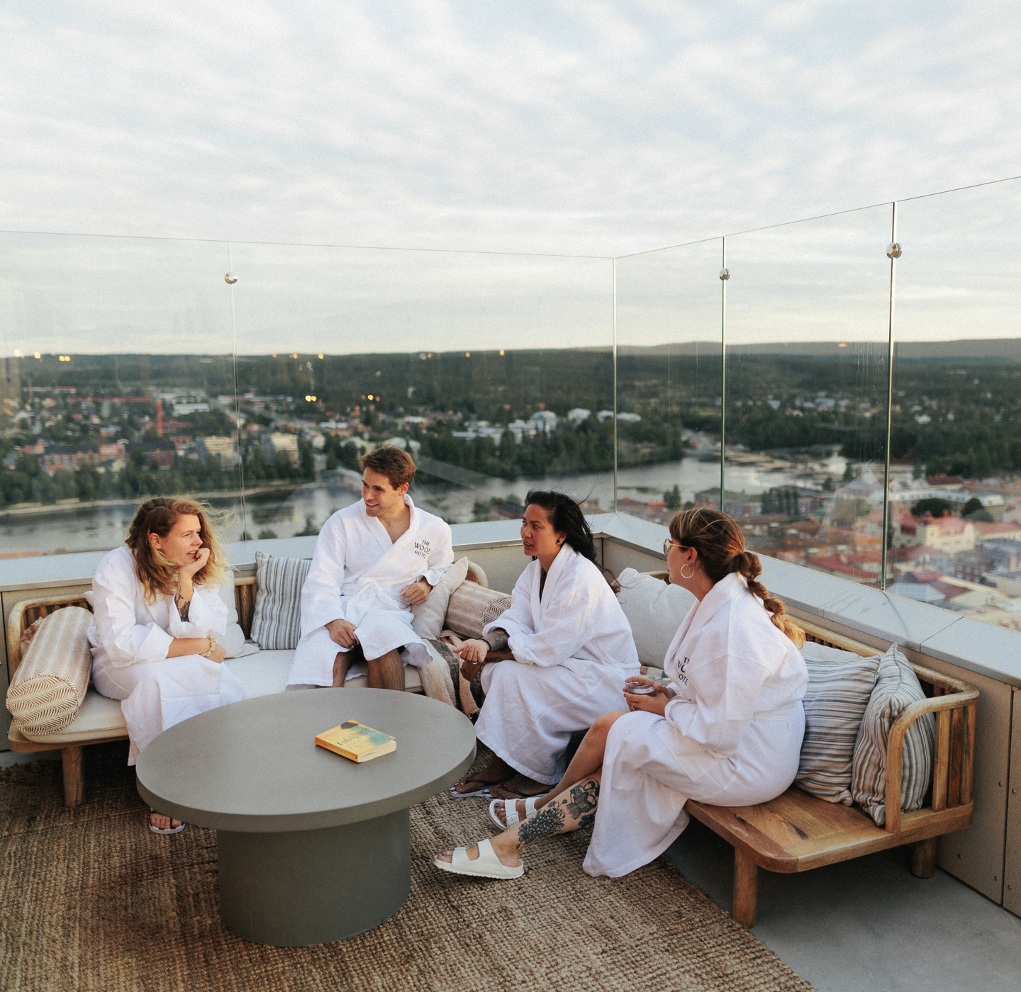 Photo: Visit Skellefteå Four people in spa bathrobes are sitting on a roof top.